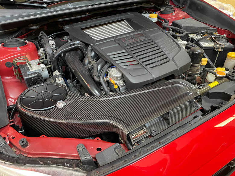 Cobb Redline intake installed in a 2015-2021 Subaru WRX FA20DIT engine bay, featuring a carbon fiber finish.