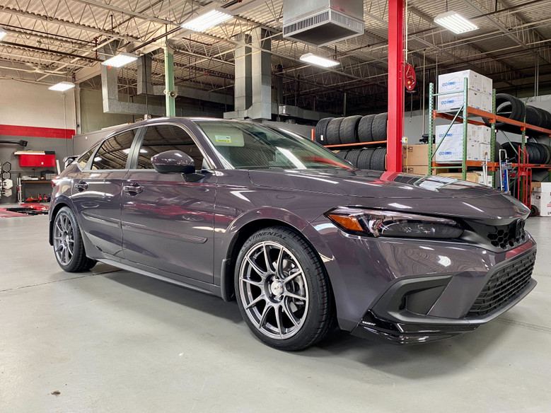 Smokey Mauve Pearl 11th Gen Honda Civic with SSR GTX01 wheels in a garage with tires and equipment in the background.